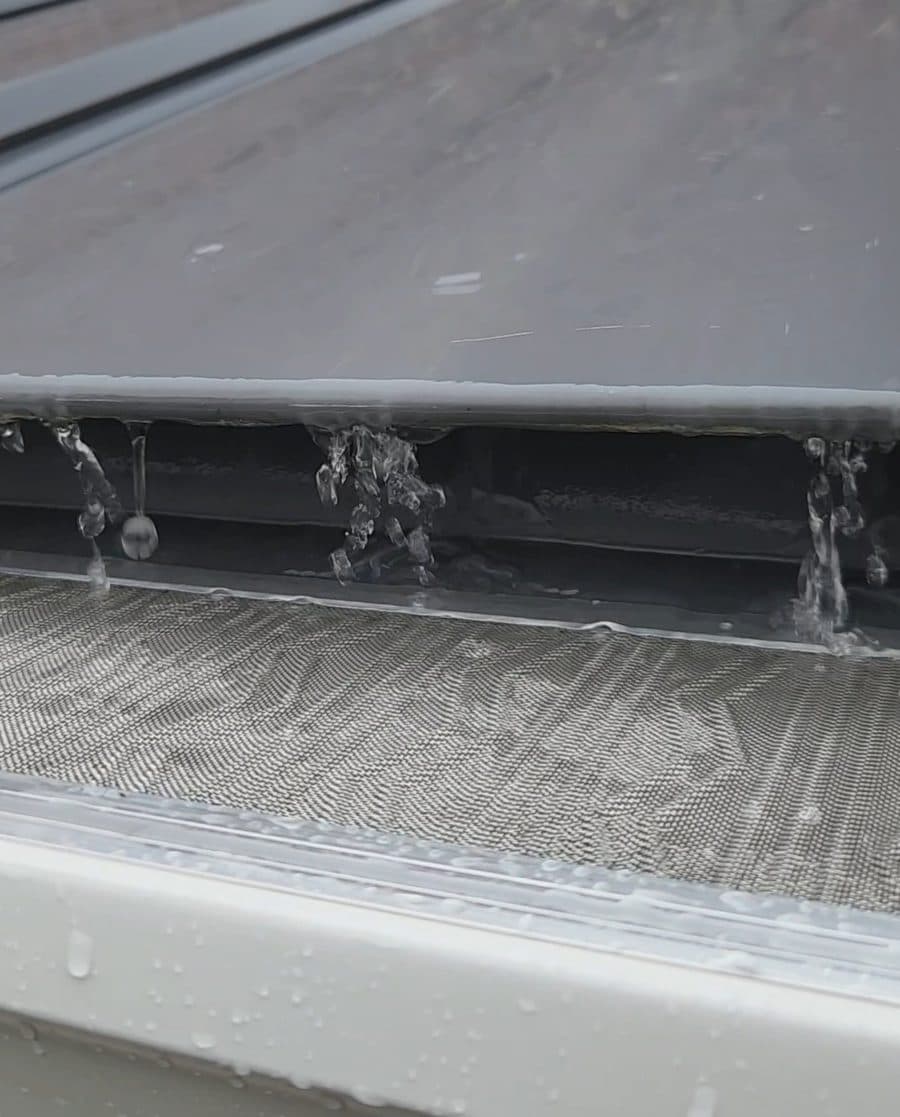 6-inch seamless gutters with micro-mesh guards channeling light rain on a metal roof, Freedom Gutters Mebane NC