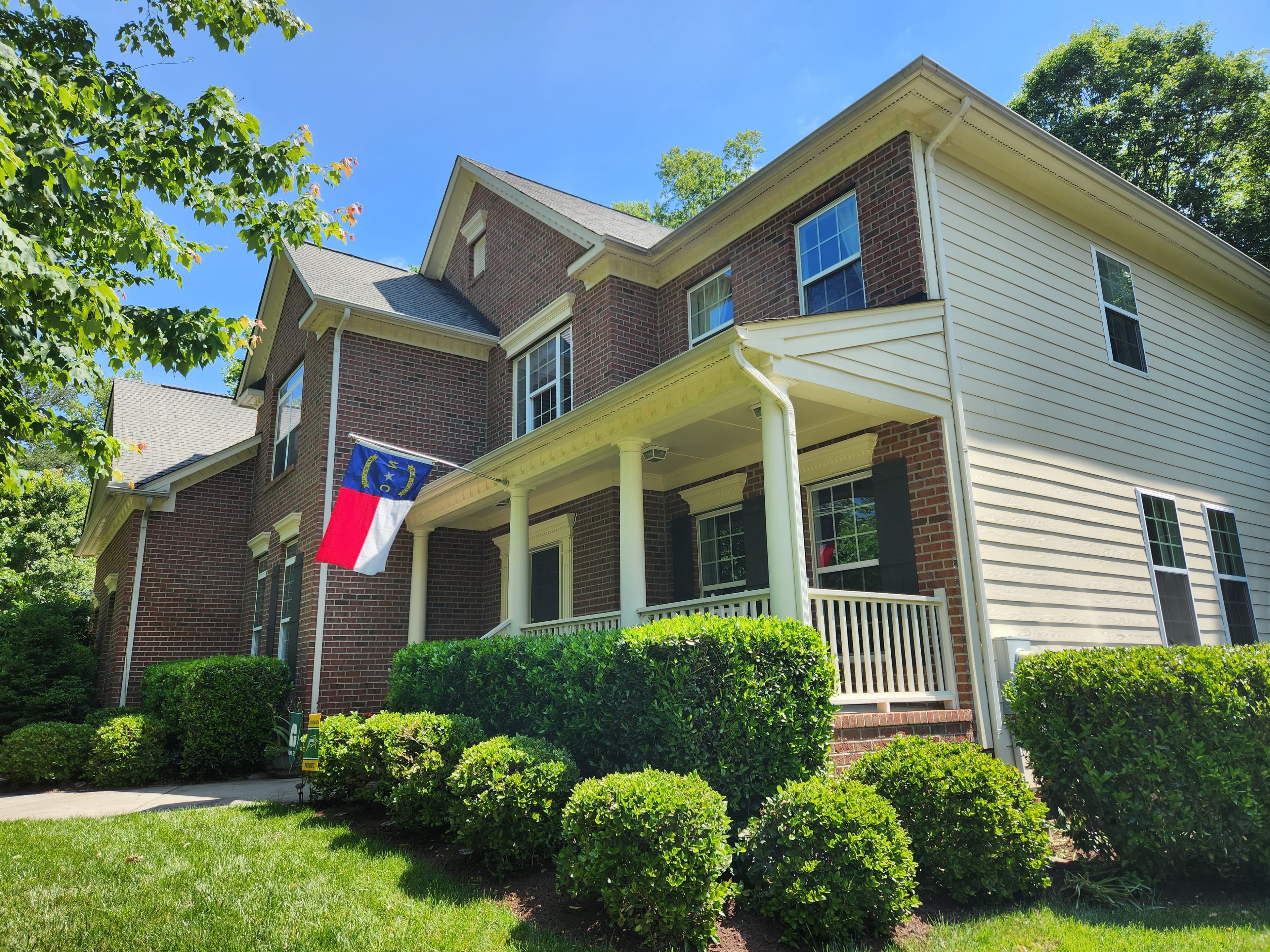 Brick colonial with white seamless gutters