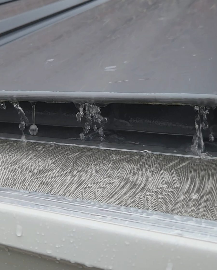 6-inch seamless gutters with micro-mesh guards channeling light rain on a metal roof, Freedom Gutters Mebane NC