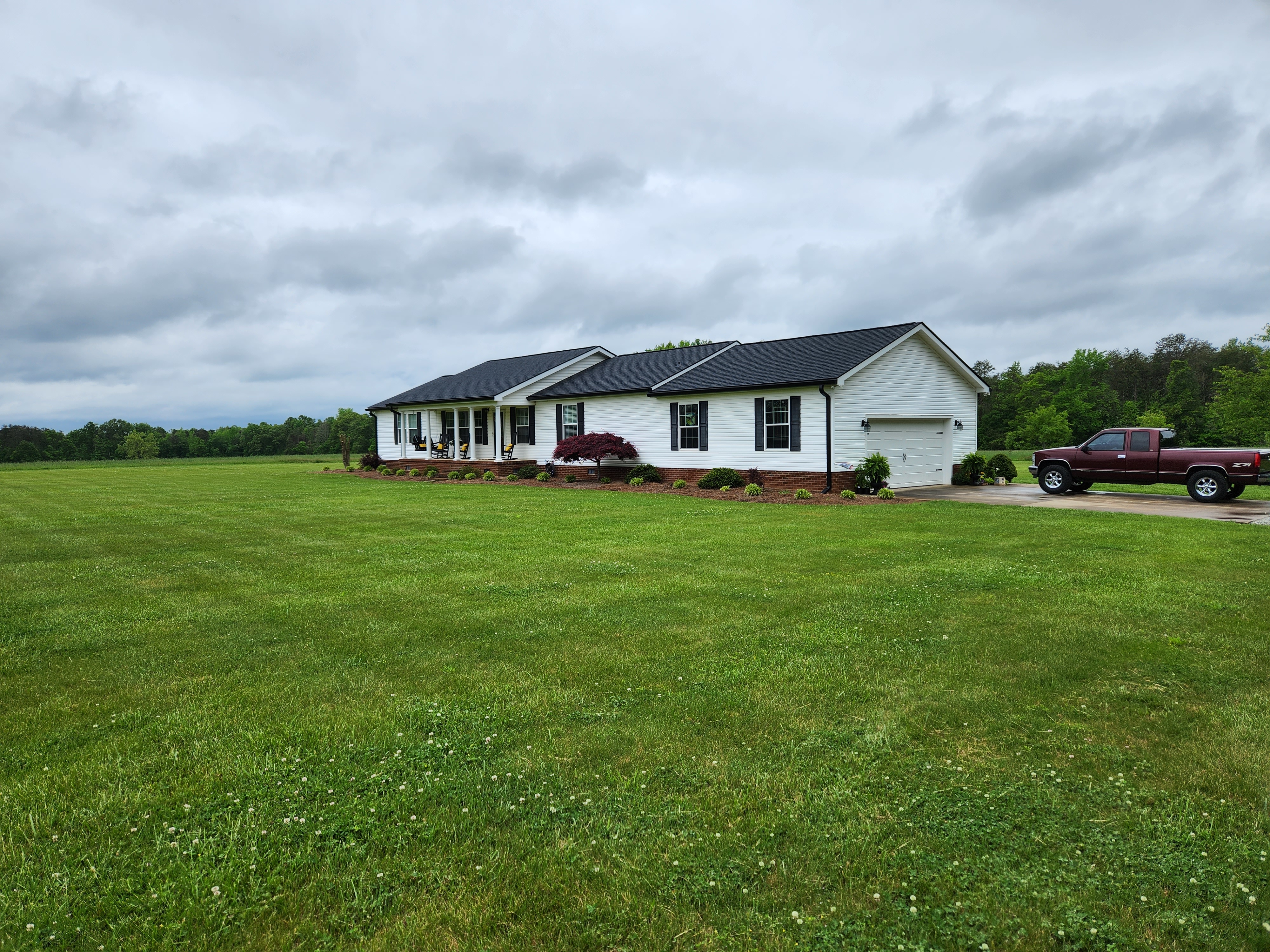 White ranch home with black seamless gutters — rural NC